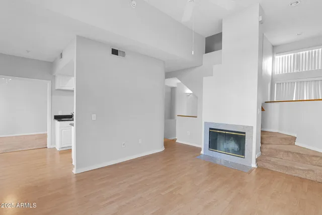 a view of empty room with wooden floor and fireplace