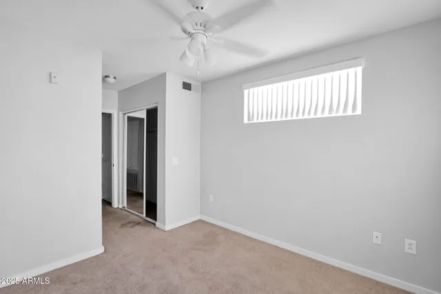 an empty room with windows and closet