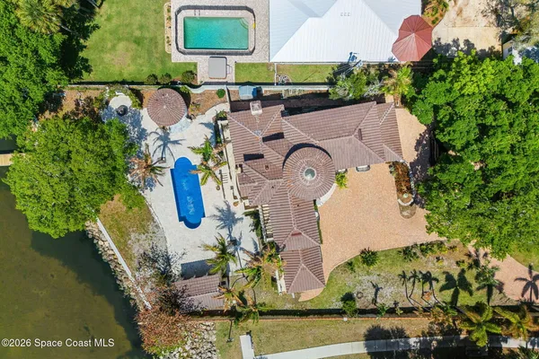 an aerial view of a house with swimming pool and outdoor seating