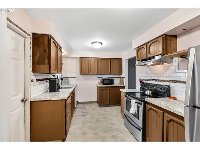 a kitchen with stainless steel appliances granite countertop a stove refrigerator sink and cabinets
