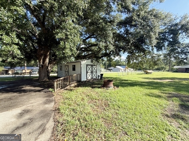 451 Lambs Bridge Road Swainsboro, GA 30401 - Photo 21 of 23 a backyard of a house with a garden and tree