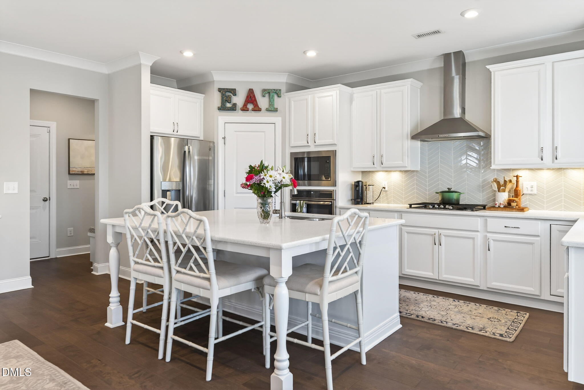 10009 Leesville Grove Drive Raleigh, NC 27613 - Photo 18 of 66 a kitchen with a dining table chairs refrigerator and cabinets