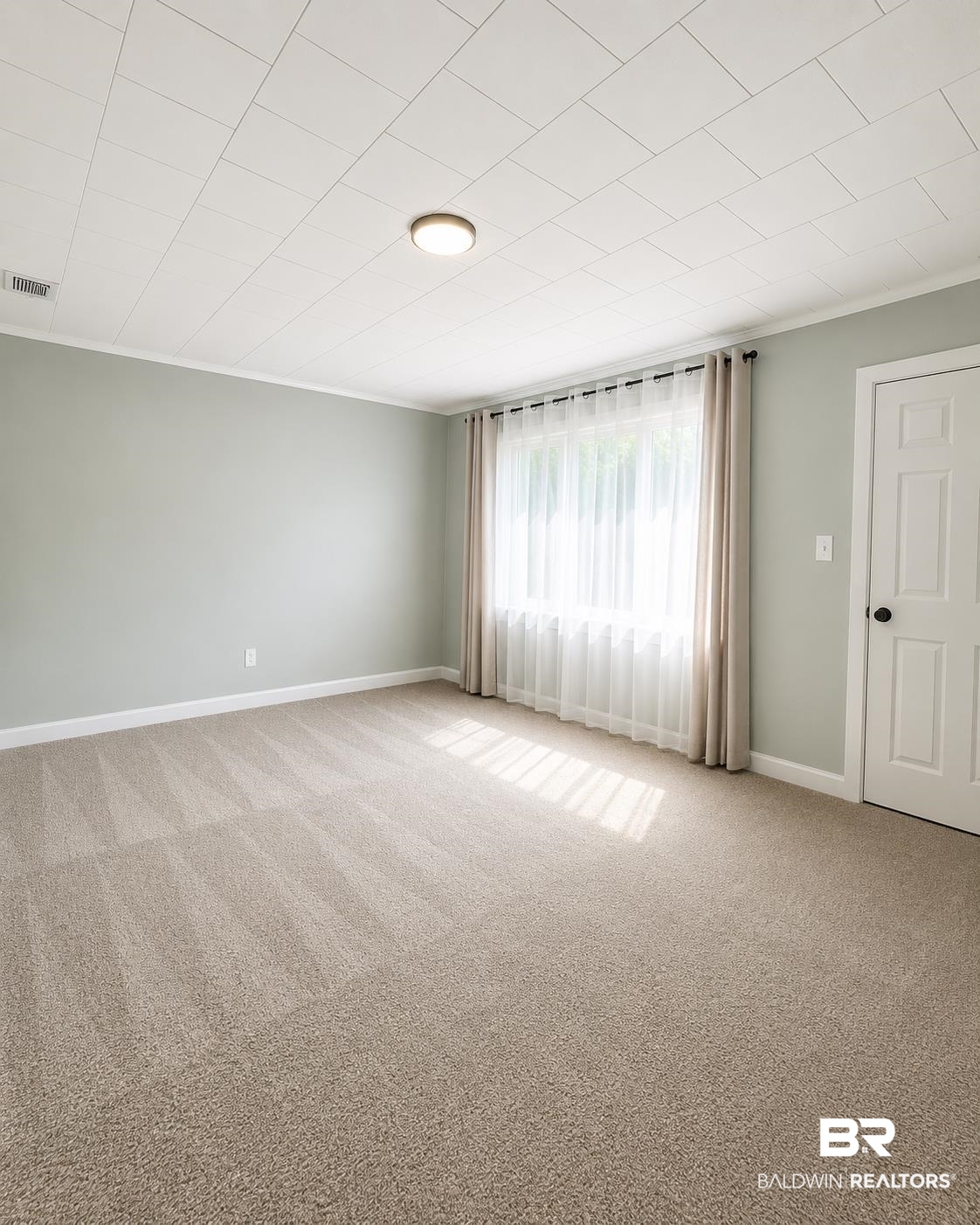 226 Elizabeth Street Evergreen, AL 36401 - Photo 15 of 35 Expansive room featuring plush carpeting, light green wall paint, and white crown molding