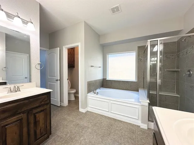 a bathroom with a tub a sink and a large mirror