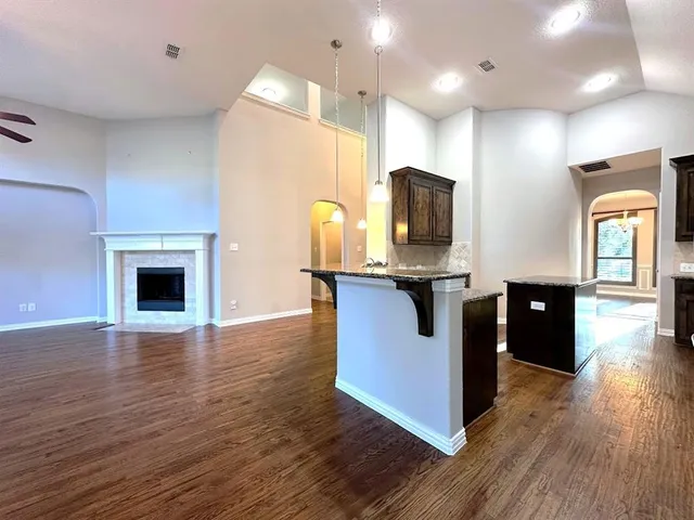 a kitchen with stainless steel appliances kitchen island granite countertop a stove and a wooden floors
