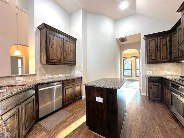 a kitchen with granite countertop stainless steel appliances and wooden cabinets