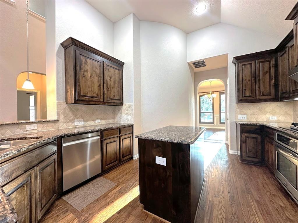2453 Ranchview Drive Little Elm, TX 75068 - Photo 4 of 22 a kitchen with granite countertop stainless steel appliances and wooden cabinets