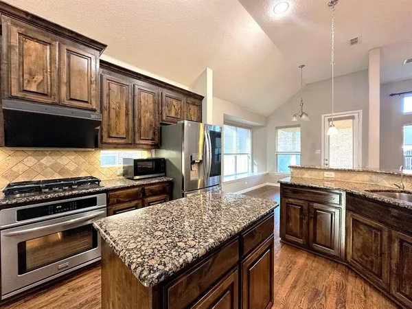 a kitchen with granite countertop stainless steel appliances and wooden cabinets