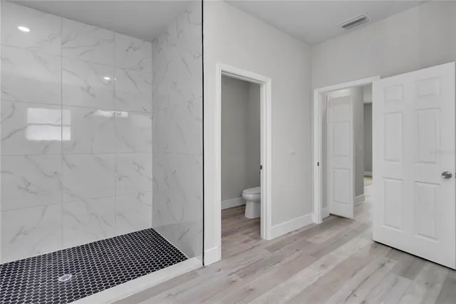a view of a room with wooden floor and bathroom
