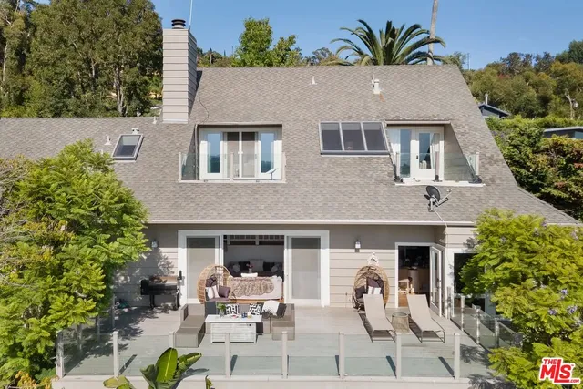 a view of a house with backyard and sitting area