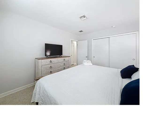 a bedroom with a bed and a flat screen tv