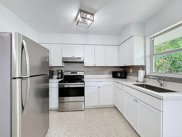 a kitchen with stainless steel appliances a refrigerator sink and cabinets