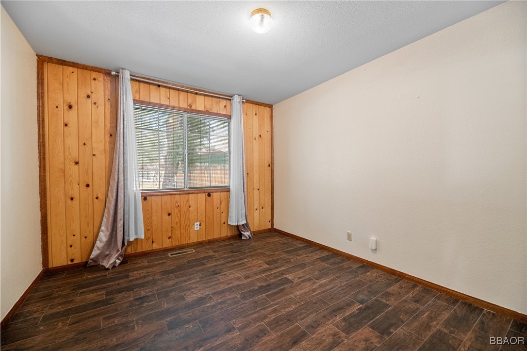 252 Riverside Avenue Sugarloaf, CA 92386 - Photo 16 of 29 a view of an empty room with wooden floor and a window