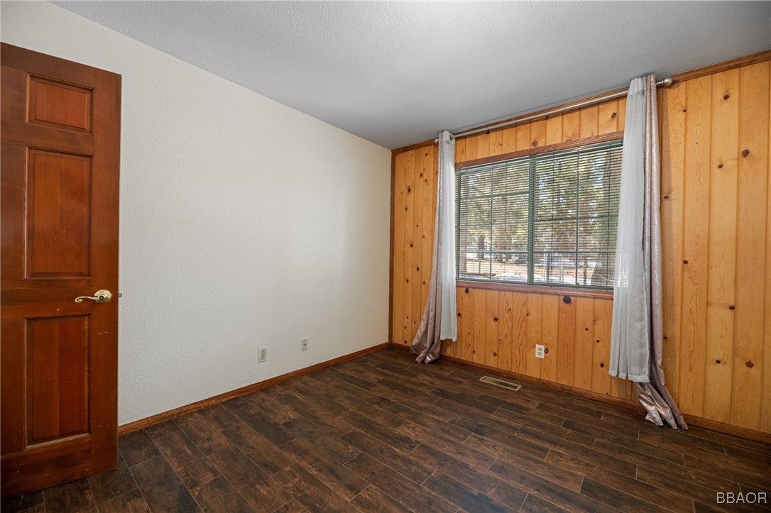252 Riverside Avenue Sugarloaf, CA 92386 - Photo 17 of 29 an empty room with wooden floor and windows