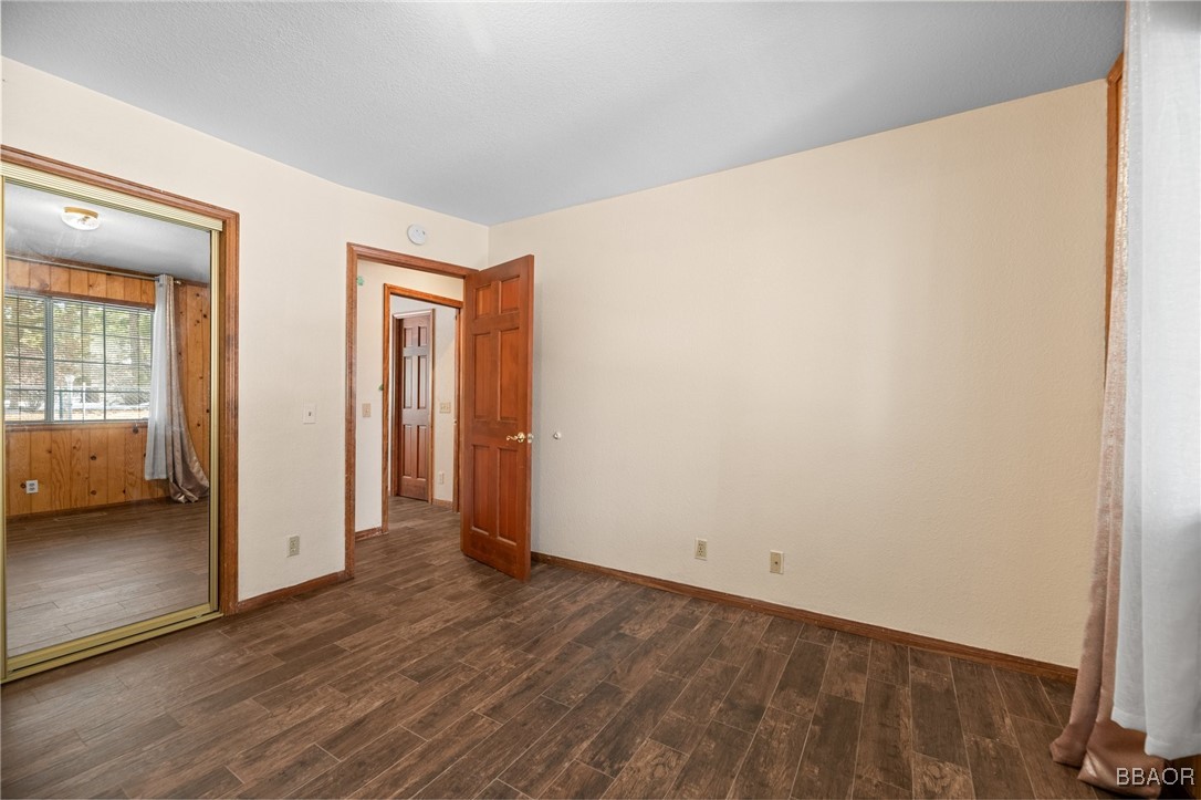 252 Riverside Avenue Sugarloaf, CA 92386 - Photo 18 of 29 an empty room with wooden floor and windows