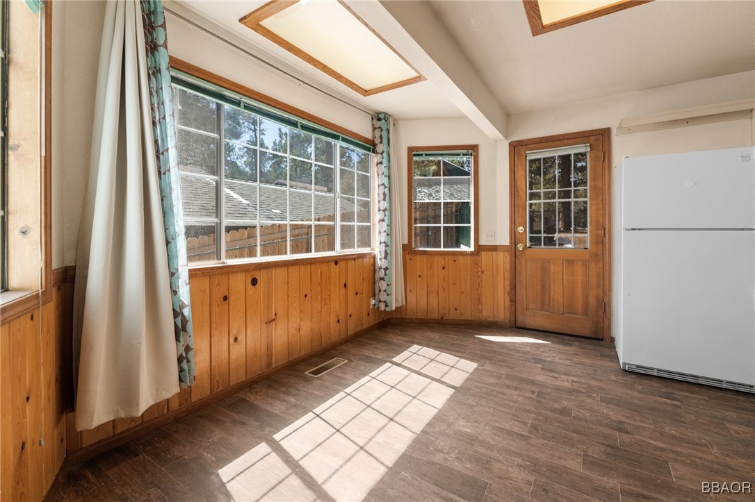 252 Riverside Avenue Sugarloaf, CA 92386 - Photo 7 of 29 an empty room with wooden floor and windows