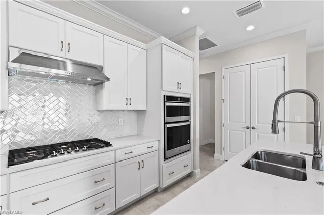 a kitchen with granite countertop a stove a sink and a refrigerator