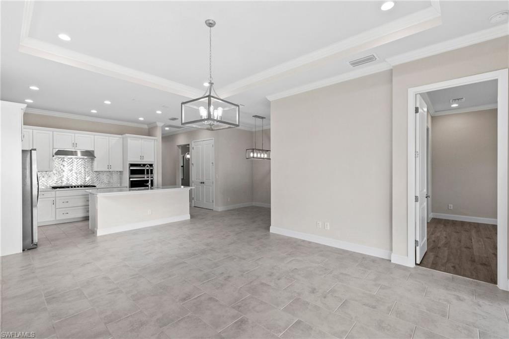 14756 Kingfisher Loop Naples, FL 34120 - Photo 11 of 31 a view of a kitchen with a refrigerator a microwave and a sink
