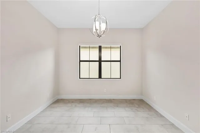 an empty room with windows and chandelier