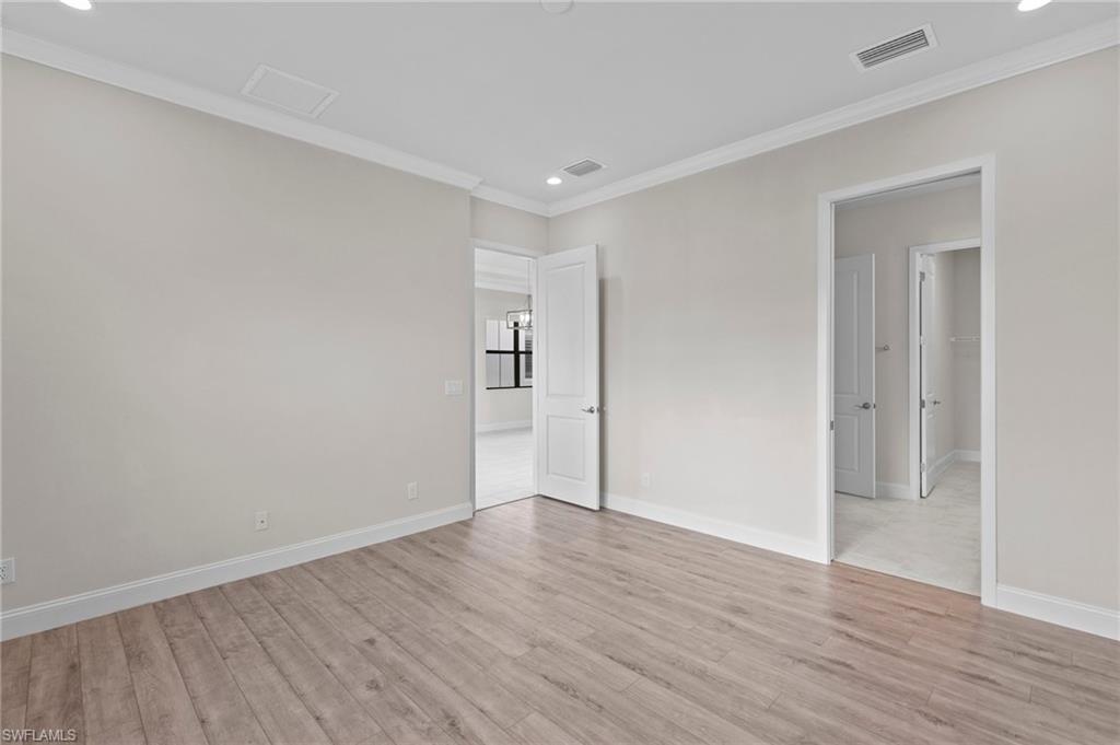 14756 Kingfisher Loop Naples, FL 34120 - Photo 13 of 31 a view of an empty room with wooden floor