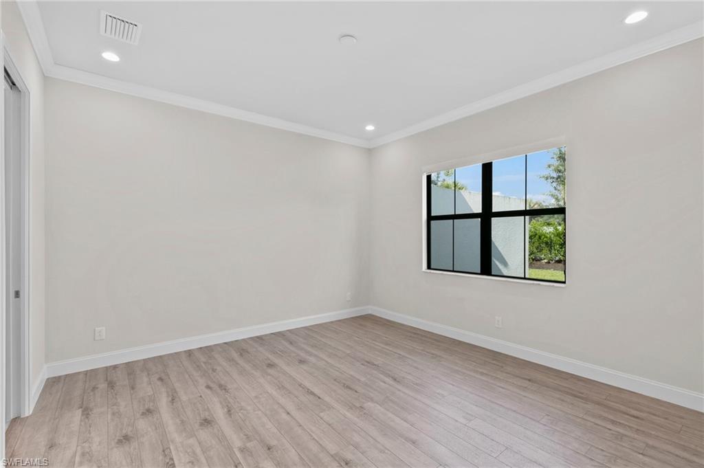 14756 Kingfisher Loop Naples, FL 34120 - Photo 14 of 31 wooden floor in an empty room with a window