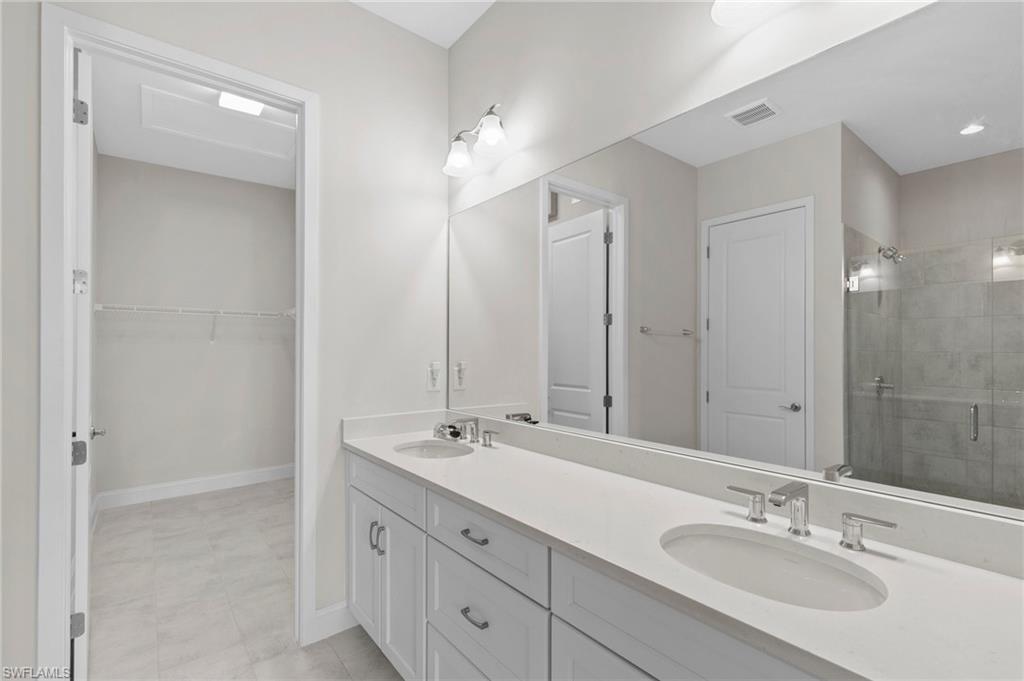14756 Kingfisher Loop Naples, FL 34120 - Photo 17 of 31 a bathroom with double vanity sink and a mirror