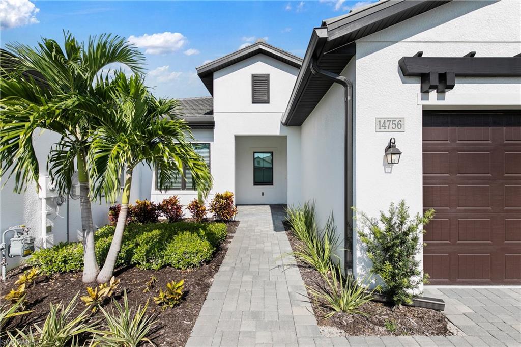 14756 Kingfisher Loop Naples, FL 34120 - Photo 2 of 31 a house with a yard and potted plants