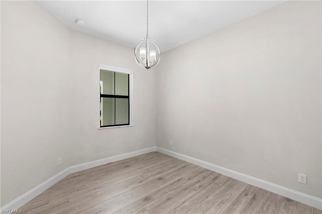 14756 Kingfisher Loop Naples, FL 34120 - Photo 21 of 31 en empty room with wooden floor and window