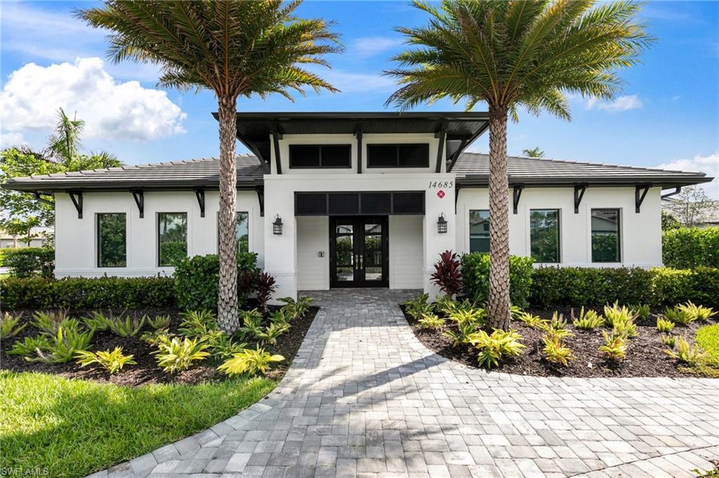 14756 Kingfisher Loop Naples, FL 34120 - Photo 29 of 31 a front view of a house with a yard and potted plants