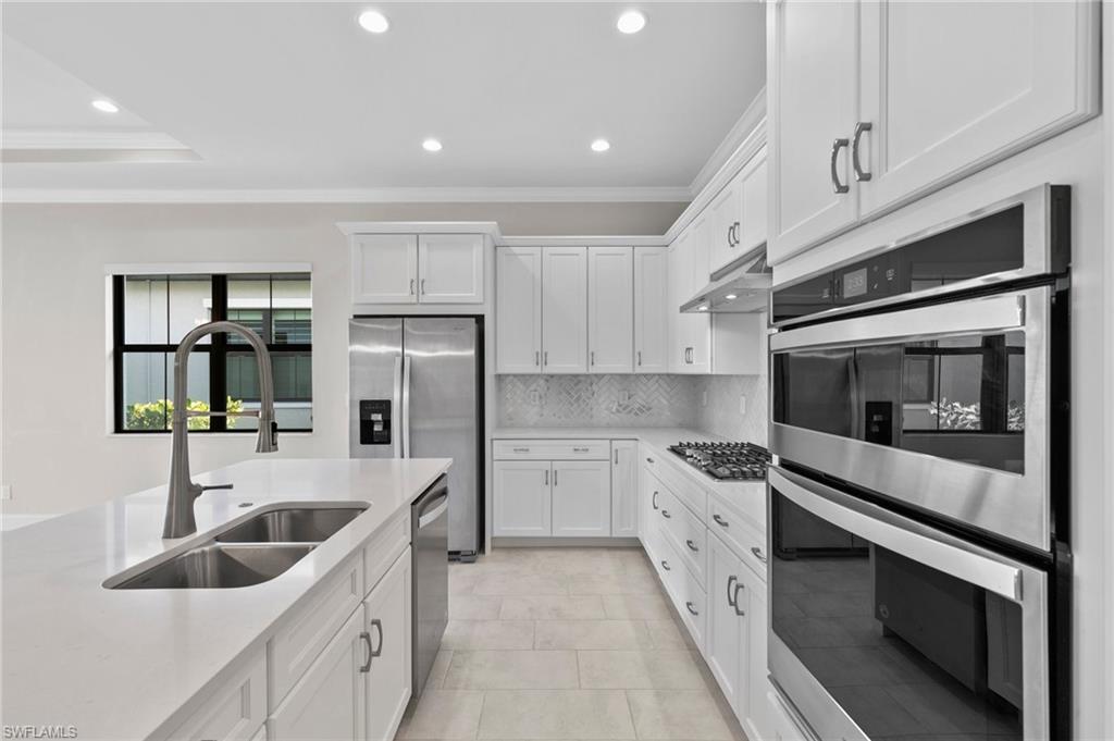 14756 Kingfisher Loop Naples, FL 34120 - Photo 4 of 31 a kitchen with stainless steel appliances granite countertop a sink and a stove