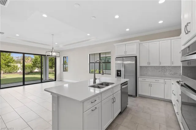 a kitchen with white cabinets and sink