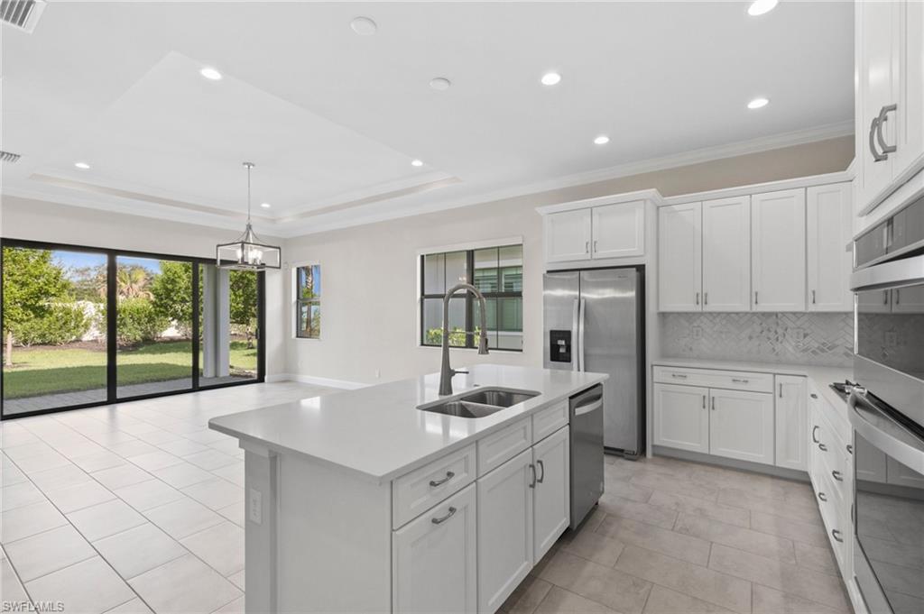 14756 Kingfisher Loop Naples, FL 34120 - Photo 8 of 31 a kitchen with white cabinets and sink
