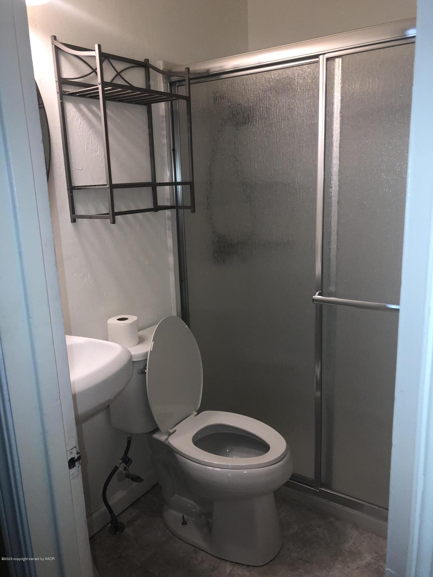 4601 South Travis Street Amarillo, TX 79110 - Photo 6 of 39 a white toilet sitting next to a shower