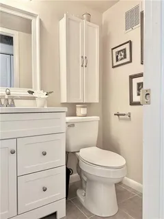 a bathroom with a toilet sink vanity and mirror