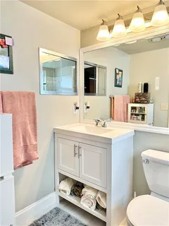 a bathroom with a sink mirror vanity and toilet