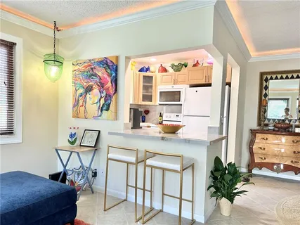 a view of a dining room with furniture one side kitchen view with wooden floor