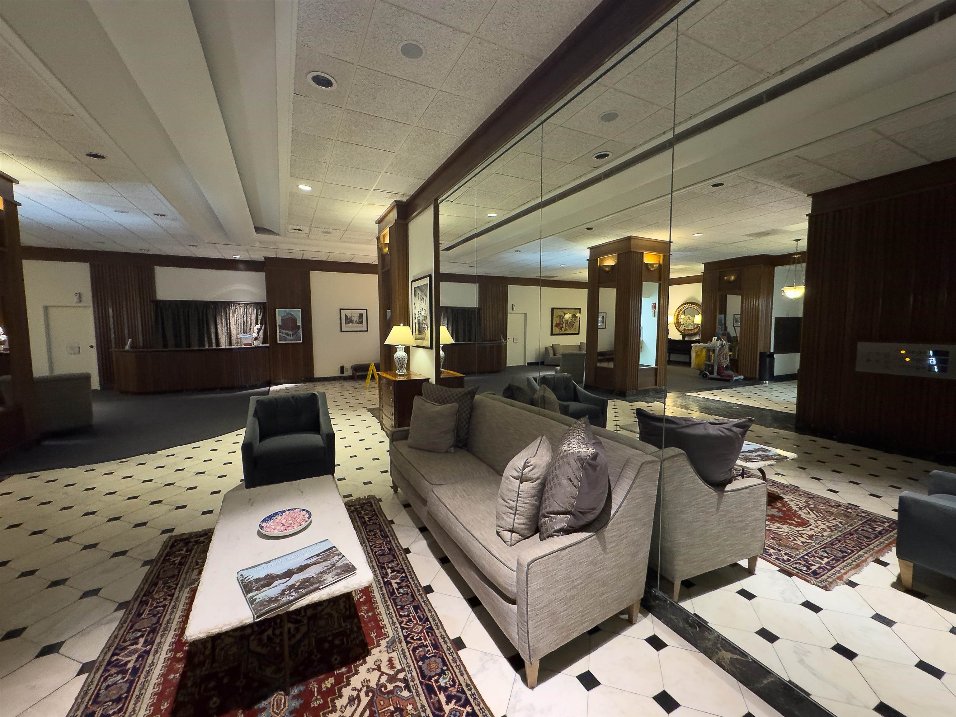 109 North Main Street, Unit 907 Memphis, TN 38103 - Photo 21 of 29 Spacious lobby featuring black and white checkered flooring, wood paneling, recessed lighting, and a mirrored wall