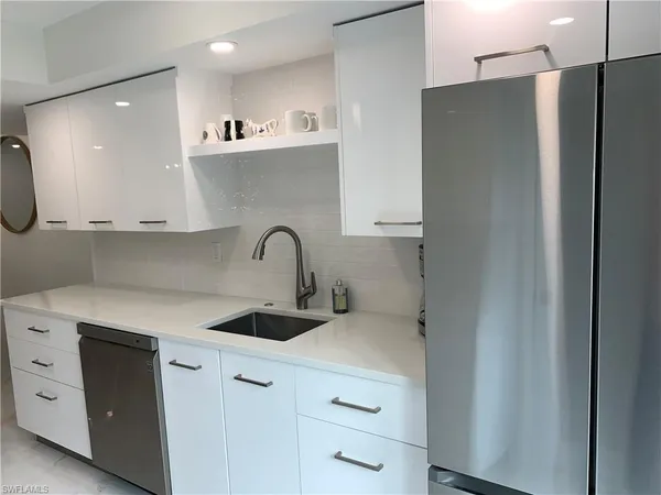 a kitchen with stainless steel appliances a refrigerator sink and cabinets