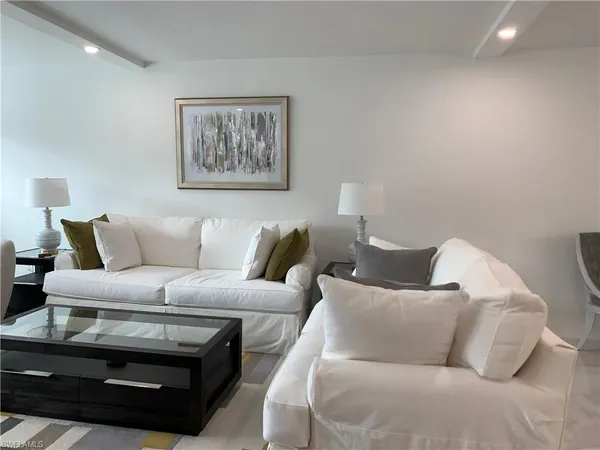 a living room with furniture a couch and painting on the wall