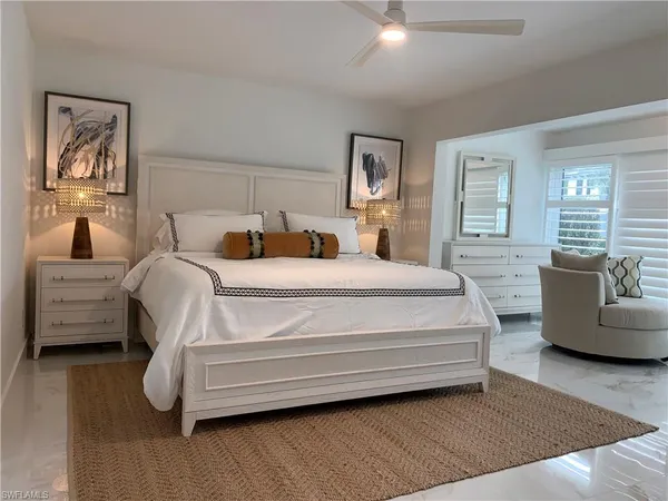 a bedroom with bed couch and window