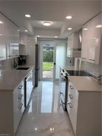 a kitchen with kitchen island a counter top space appliances and a sink