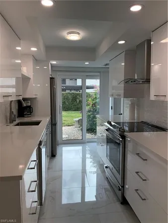 a kitchen with granite countertop a stove a sink and a refrigerator