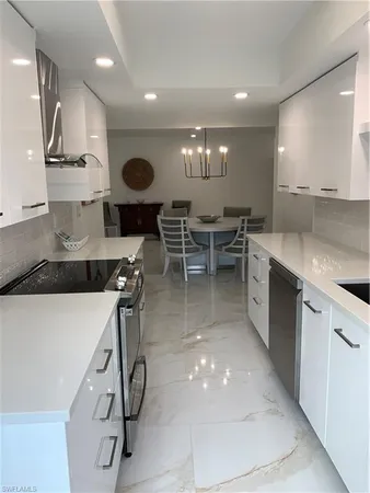 a kitchen with stainless steel appliances a sink a stove and a wooden floors