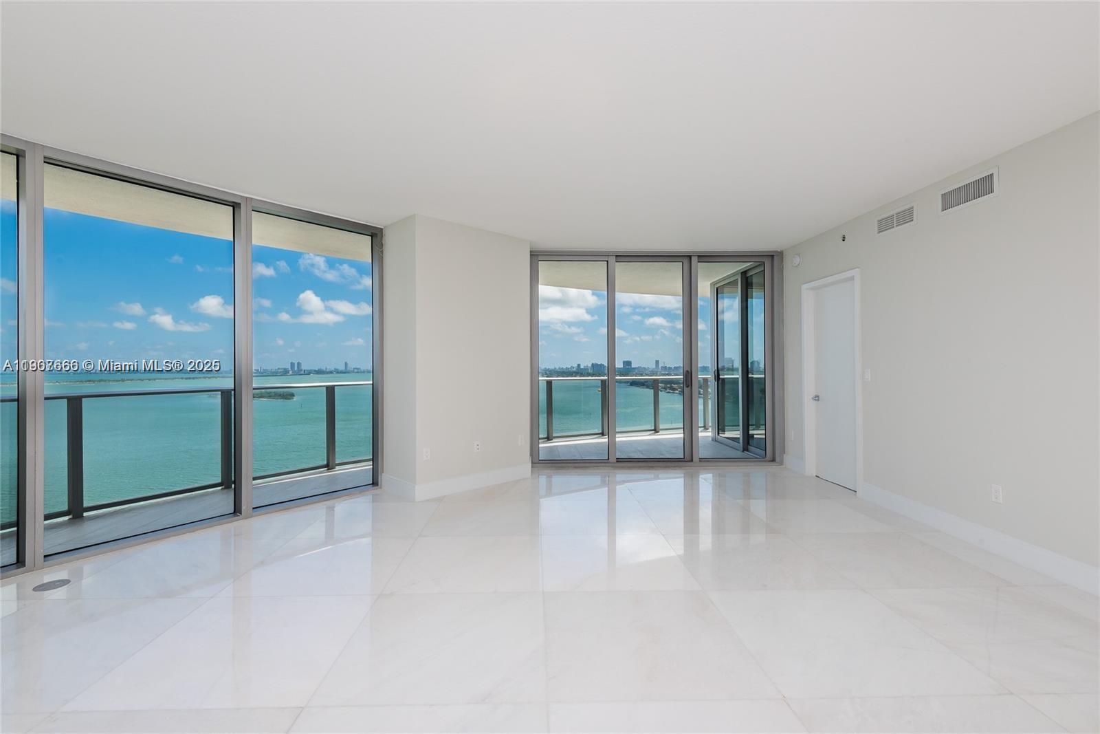 488 Northeast 18th Street, Unit 1815 Miami, FL 33132 - Photo 19 of 31 an empty room with floor to ceiling windows and an outdoor view