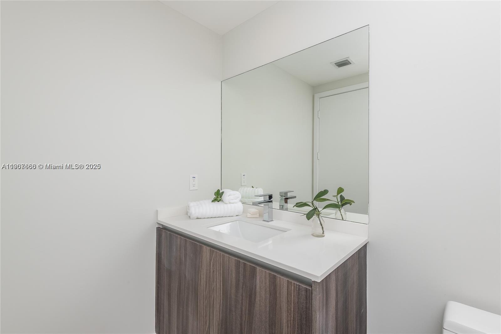 488 Northeast 18th Street, Unit 1815 Miami, FL 33132 - Photo 24 of 31 a bathroom with a sink and a mirror