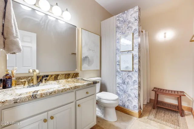 a bathroom with a granite countertop sink toilet and shower