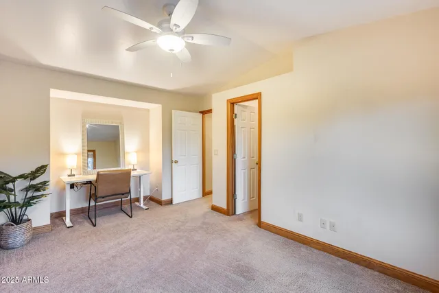 an empty room with furniture and a ceiling fan