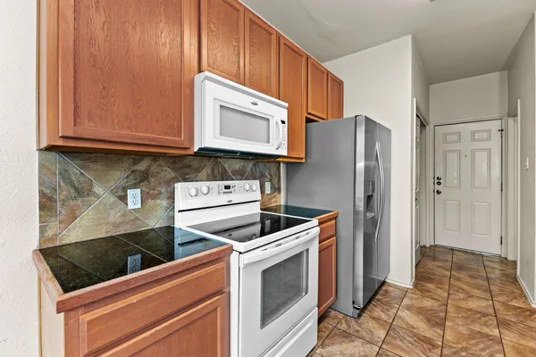 a kitchen with stainless steel appliances granite countertop a refrigerator and a stove top oven