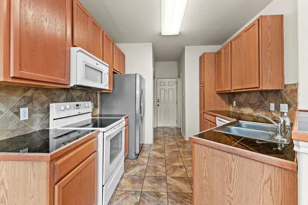 a kitchen with stainless steel appliances granite countertop a stove a sink and a refrigerator