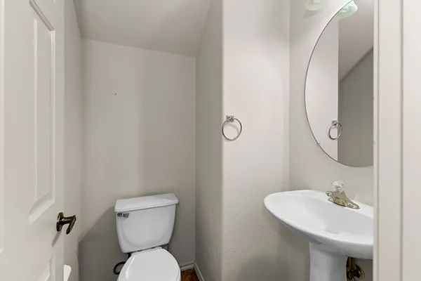 a bathroom with a toilet sink and a mirror